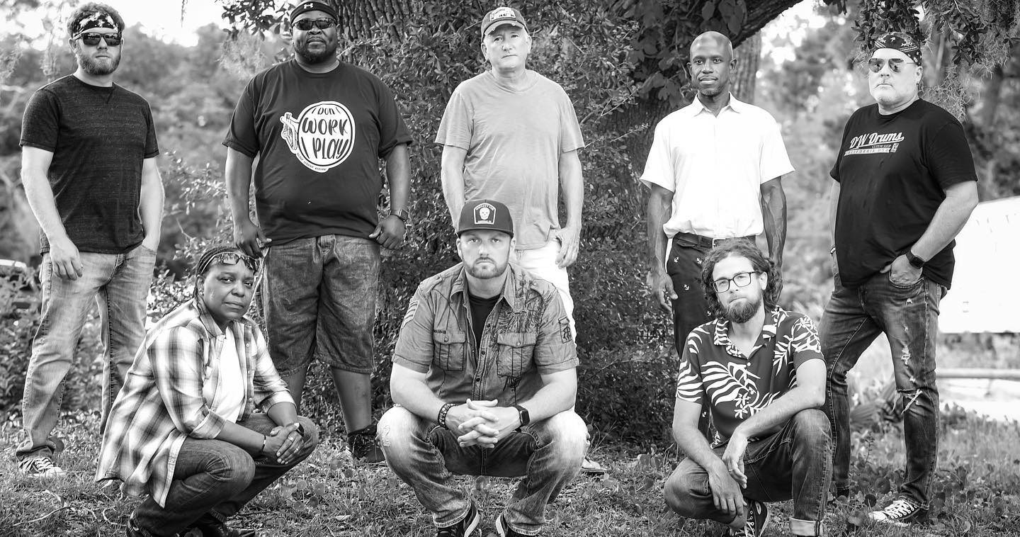 Jebb Mac Band, five members in the back row, three in front, standing in front of a large oak tree.