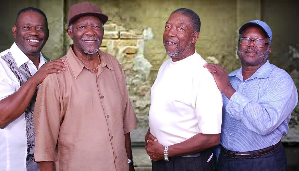 a group of four African American men standing in front of a brick wall, award-winning gospel group